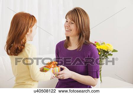 Stock Image - USA, Illinois, Metamora, Daughter (4-5) giving present to her mother. Fotosearch