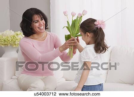 Stock Image - USA, Illinois, Metamora, daughter (4-5) giving bouquet to mother. Fotosearch