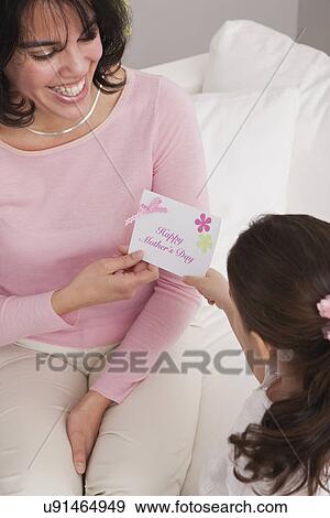 Stock Photo - USA, Illinois, Metamora, daughter (4-5) giving greeting card to mother. Fotosearch