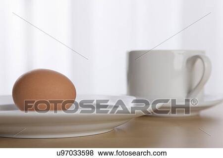 Stock Photo - USA, Illinois, Metamora, Egg on plate with coffee cup. Fotosearch