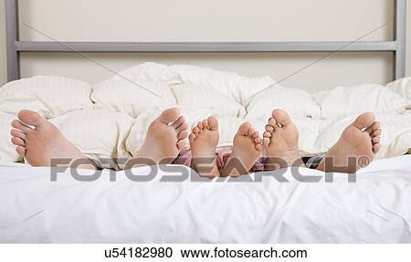 Stock Image - USA, Illinois, Metamora, Family in bed. Fotosearch