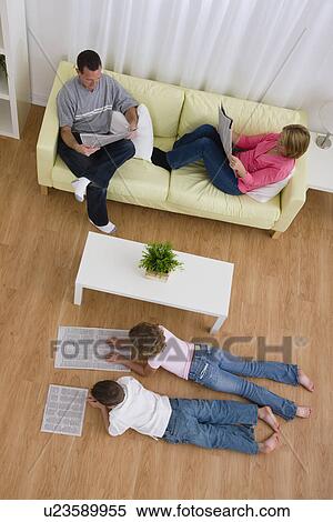 USA, Illinois, Metamora, Family reading newspapers in living room View Large Photo Image Stock Photography - USA, Illinois, Metamora, Family reading newspapers in living room. Fotosearch