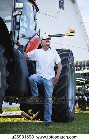 Stock Photo - USA, Illinois, Metamora, Farmer by tractor in field. Fotosearch