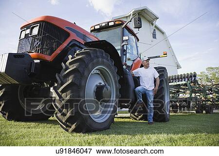 USA, Illinois, Metamora, Farmer by tractor in field View Large Photo Image Stock Photo - USA, Illinois, Metamora, Farmer by tractor in field. Fotosearch