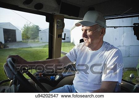 USA, Illinois, Metamora, Farmer driving tractor on farm View Large Photo Image Stock Photo - USA, Illinois, Metamora, Farmer driving tractor on farm. Fotosearch