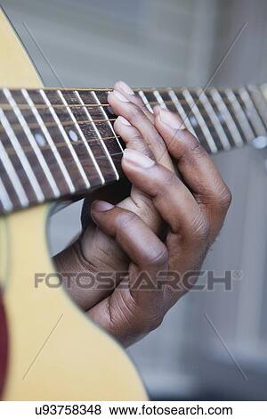 Stock Photo - USA, Illinois, Metamora, Fathers and son (6-7) hands on guitar's neck. Fotosearch