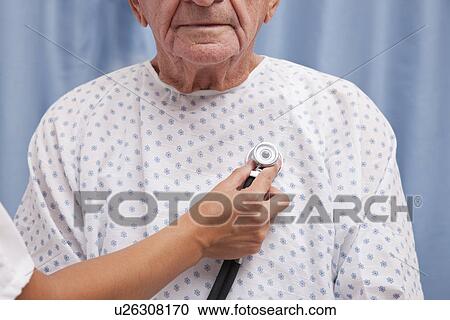 Stock Image - USA, Illinois, Metamora, Female doctor examining senior man. Fotosearch