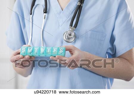 USA, Illinois, Metamora, Female doctor holding pill container View Large Photo Image Stock Photo - USA, Illinois, Metamora, Female doctor holding pill container. Fotosearch