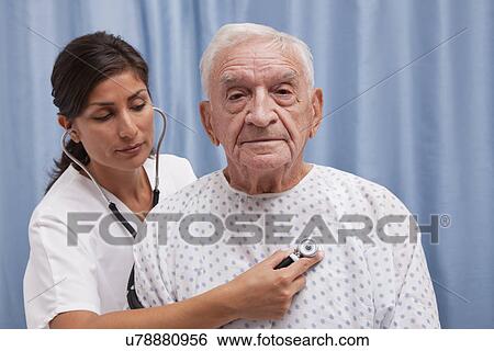USA, Illinois, Metamora, Female doctor examining senior man sitting on hospital bed View Large Photo Image Stock Photograph - USA, Illinois, Metamora, Female doctor examining senior man sitting on hospital bed. Fotosearch