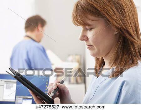 USA, Illinois, Metamora, Female nurse working with digital tablet in hospital View Large Photo Image Stock Photo - USA, Illinois, Metamora, Female nurse working with digital tablet in hospital. Fotosearch