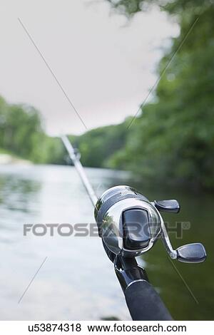 Stock Photo - USA, Illinois, Metamora, Fishing pole over river. Fotosearch
