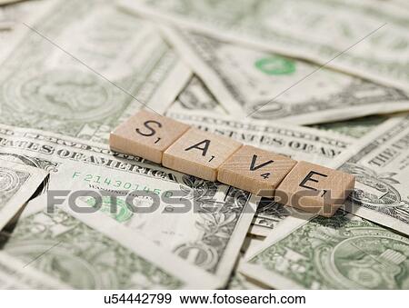 Stock Photo - USA, Illinois, Metamora, Game pieces with financial words lying on money. Fotosearch