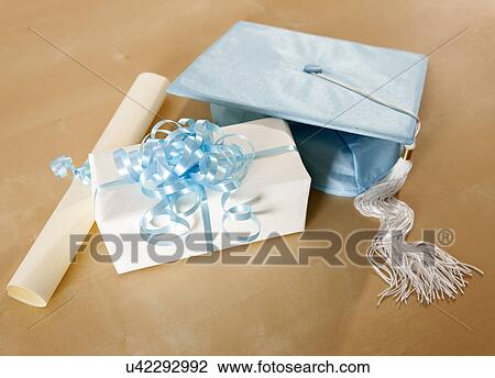 Stock Image - USA, Illinois, Metamora, Gift box, mortar board and diploma. Fotosearch