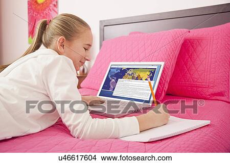 USA, Illinois, Metamora, Girl (10-11) with laptop lying on bed View Large Photo Image Picture - USA, Illinois, Metamora, Girl (10-11) with laptop lying on bed. Fotosearch