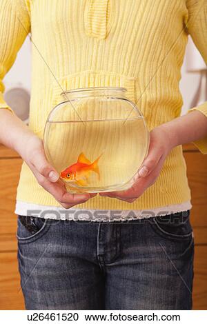 Stock Image - USA, Illinois, Metamora, Girl (10-11) holding golfish in fishbowl. Fotosearch