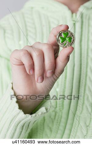 USA, Illinois, Metamora, Girl (10-11) holding coin with shamrock sign View Large Photo Image Stock Image - USA, Illinois, Metamora, Girl (10-11) holding coin with shamrock sign. Fotosearch