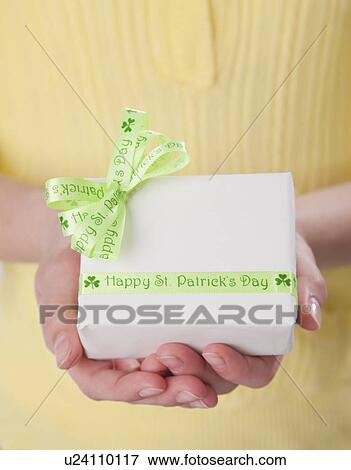 Stock Photo - USA, Illinois, Metamora, Girl (10-11) holding small box with green ribbon. Fotosearch