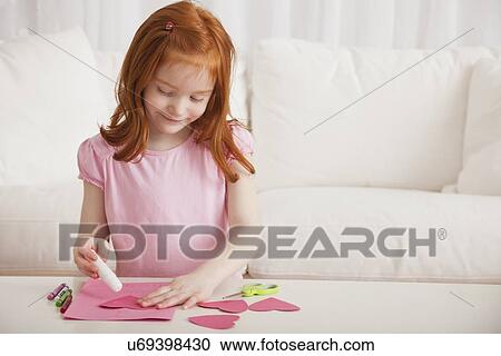 Stock Image - USA, Illinois, Metamora, Girl (4-5) hands preparing greeting card for Mother's Day. Fotosearch