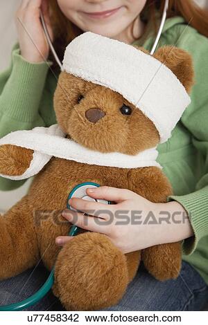 USA, Illinois, Metamora, Girl (4-5) playing with teddy bear and stethoscope View Large Photo Image Stock Image - USA, Illinois, Metamora, Girl (4-5) playing with teddy bear and stethoscope. Fotosearch