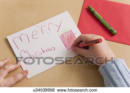Stock Photo - USA, Illinois, Metamora, Girl (4-5) writing Christmas greetings. Fotosearch