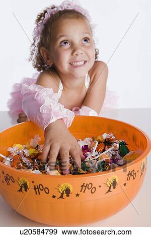 USA, Illinois, Metamora, Girl (6-7) in costume taking candies from bowl View Large Photo Image Stock Photo - USA, Illinois, Metamora, Girl (6-7) in costume taking candies from bowl. Fotosearch