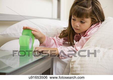 USA, Illinois, Metamora, Girl (6-7) in bed checking alarm clock View Large Photo Image Stock Photograph - USA, Illinois, Metamora, Girl (6-7) in bed checking alarm clock. Fotosearch