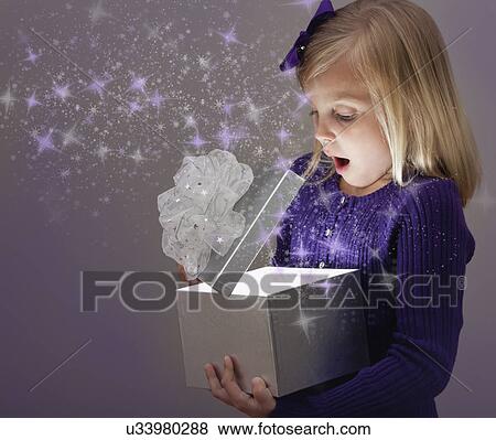 Stock Photo - USA, Illinois, Metamora, Girl (6-7) opening gift box. Fotosearch