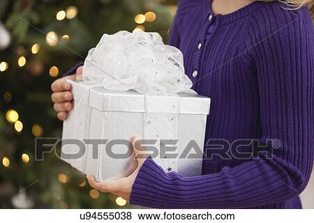 Stock Photo - USA, Illinois, Metamora, Girl (6-7) holding gift box. Fotosearch