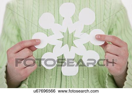Stock Photograph - USA, Illinois, Metamora, girl (6-7) holding paper snowflake. Fotosearch