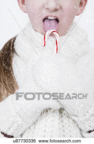 USA, Illinois, Metamora, girl (6-7) wearing wool gloves and scarf licking candy cane View Large Photo Image Stock Photograph - USA, Illinois, Metamora, girl (6-7) wearing wool gloves and scarf licking candy cane. Fotosearch