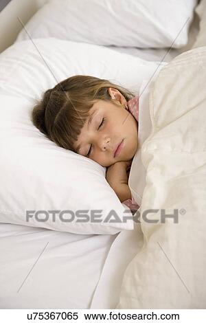 Stock Photography - USA, Illinois, Metamora, Girl (6-7) sleeping in bed. Fotosearch