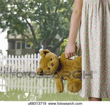 USA, Illinois, Metamora, Girl (8-9) holding teddy in flooded yard View Large Photo Image Stock Photo - USA, Illinois, Metamora, Girl (8-9) holding teddy in flooded yard. Fotosearch