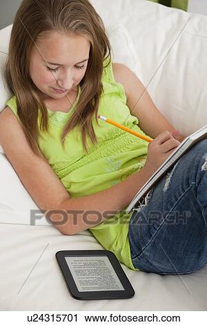 Stock Image - USA, Illinois, Metamora, Girl doing homework using tablet pc. Fotosearch