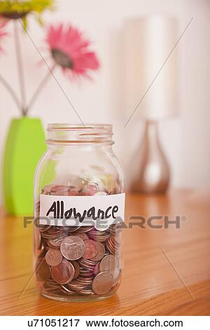 Stock Photo - USA, Illinois, Metamora, Glass jar with coins on table. Fotosearch