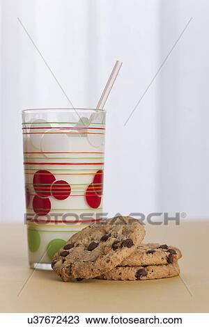 Stock Image - USA, Illinois, Metamora, Glass of milk and cookies on table. Fotosearch