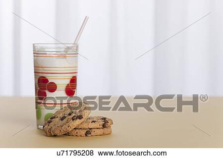 Stock Photo - USA, Illinois, Metamora, Glass of milk and cookies on table. Fotosearch