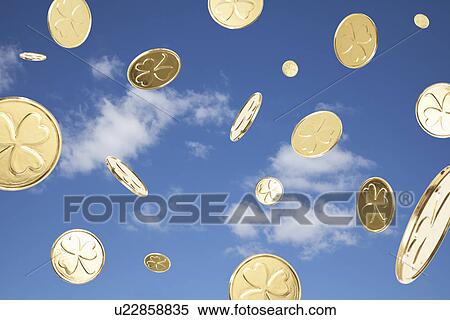 Stock Photography - USA, Illinois, Metamora, Golden coins flying in sky. Fotosearch