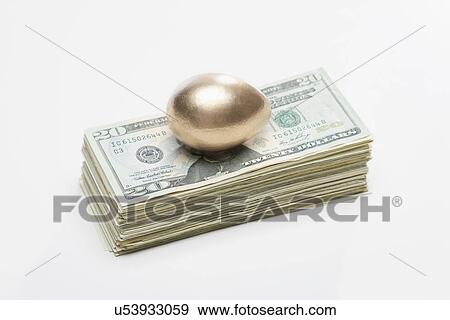 Stock Photo - USA, Illinois, Metamora, Golden egg on top of US money. Fotosearch