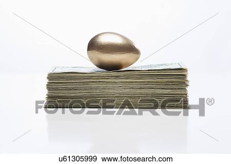 USA, Illinois, Metamora, Golden egg on top of US money View Large Photo Image Stock Photo - USA, Illinois, Metamora, Golden egg on top of US money. Fotosearch