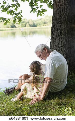 USA, Illinois, Metamora, grandfather and granddaughter (4-5) sitting at edge of lake View Large Photo Image Stock Image - USA, Illinois, Metamora, grandfather and granddaughter (4-5) sitting at edge of lake. Fotosearch