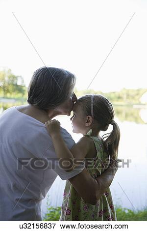 Stock Photo - USA, Illinois, Metamora, grandmother kissing granddaughter (4-5). Fotosearch