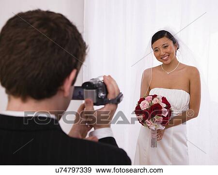 USA, Illinois, Metamora, Groom videoing bride holding bouquet View Large Photo Image Stock Photo - USA, Illinois, Metamora, Groom videoing bride holding bouquet. Fotosearch