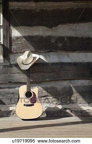 Stock Photography - USA, Illinois, Metamora, Guitar and cowboy hat in front of old building. Fotosearch