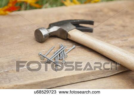 Stock Image - USA, Illinois, Metamora, Hammer and nails on wood. Fotosearch