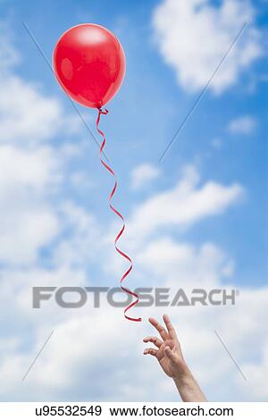 USA, Illinois, Metamora, hand reaching for red balloon View Large Photo Image Stock Photo - USA, Illinois, Metamora, hand reaching for red balloon. Fotosearch