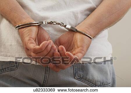 Stock Photo - USA, Illinois, Metamora, Handcuffed man. Fotosearch