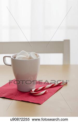 Stock Photography - USA, Illinois, Metamora, Hot Chocolate with marshmallows and candy cane on table. Fotosearch