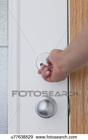 Stock Photo - USA, Illinois, Metamora, Human hand opening door. Fotosearch