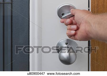 Stock Photo - USA, Illinois, Metamora, Human hand opening door. Fotosearch