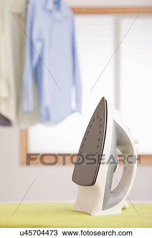 Stock Image - USA, Illinois, Metamora, iron on ironing board. Fotosearch